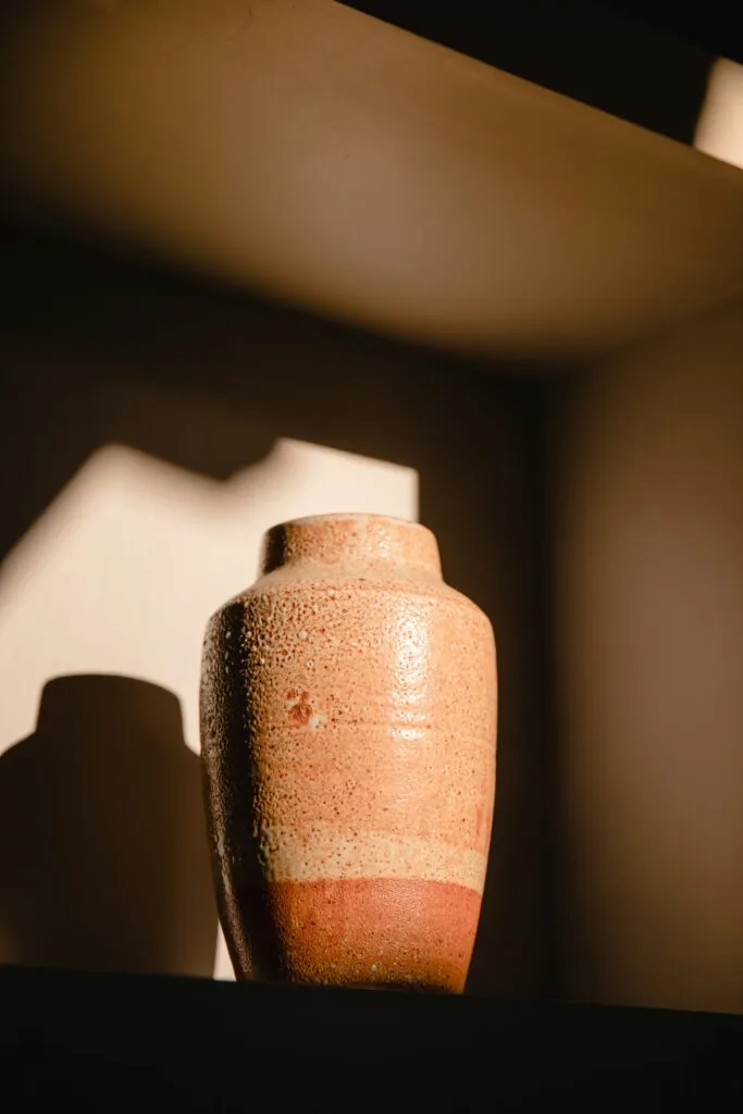 Vase en céramique artisanale texturée éclairé par une lumière rasante